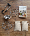 Pressure canning equipment including a recipe book on a wooden surface